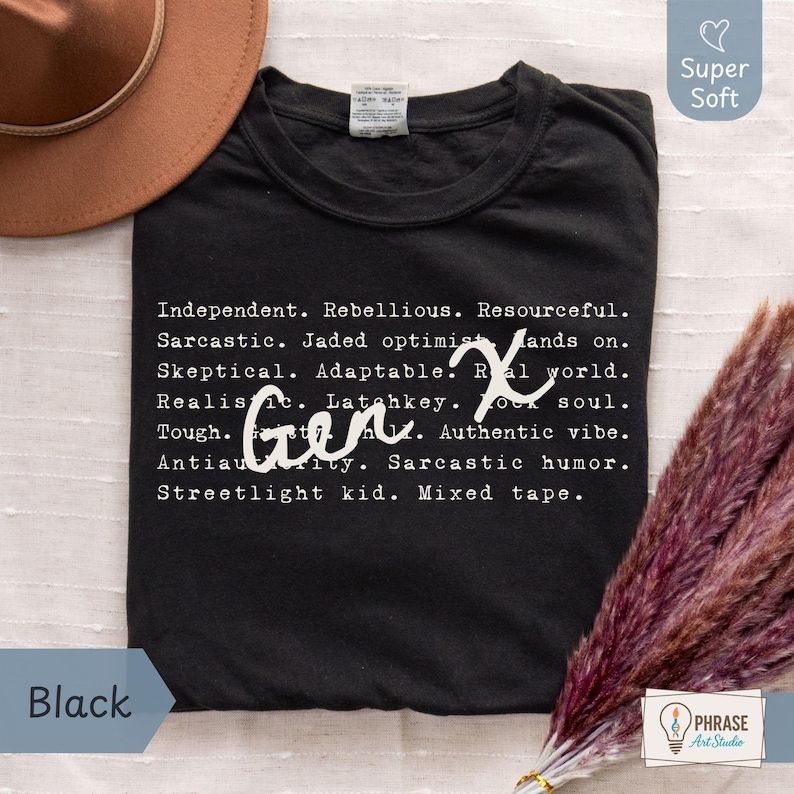 Black Comfort Colors Gen X humor t-shirt featuring sarcastic and satirical Gen X traits in a white typewriter-style print with handwritten “Gen X” overlay. Made from 100% ring-spun cotton, garment-dyed for a soft vintage feel, and pre-shrunk for comfort. Displayed flat with a brown hat and dried florals for a cozy aesthetic. Perfect for Generation X adults who love witty humor, 80s 90s nostalgia, and classic retro style. Great funny Gen X gift or laid-back everyday shirt for casual wear.