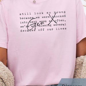 Lifestyle photo of a person wearing a super soft Comfort Colors “Blossom” pink tee with Gen X quote text in typewriter font and script “Gen X.” Styled with denim shorts, a cozy cardigan, and a necklace for casual everyday wear. Funny Gen X nostalgia shirt for coffee runs, errands, birthdays, reunions, and 90s throwback days - designed by PhraseArtStudio, Still Kickin Club.