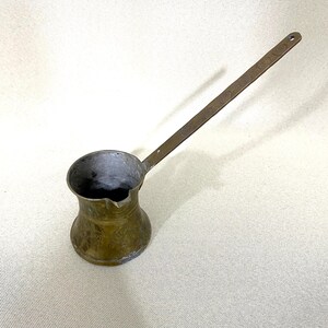 Può includere: Caffettiera turca antica in ottone con un manico lungo. La caffettiera ha un design ornamentale ed è perfetta per preparare il caffè turco tradizionale.