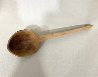 May include: A wooden ladle with a long handle and a rounded bowl. The ladle is made of light brown wood and has a natural finish.
