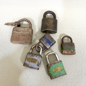 May include: Six vintage padlocks in a variety of colours and styles. The padlocks are made of metal and feature different designs. Some of the padlocks have a blue and white design, while others have a green and white design. The padlocks are all in good condition and would be a great addition to any collection.