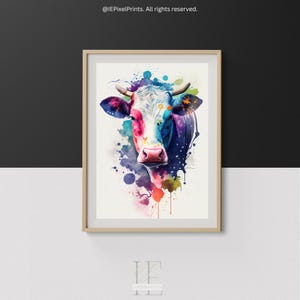 Op de afbeelding: Een kleurrijk aquarel schilderij van een koeienkop met spatten van roze, blauwe, groene en gele verf. De ogen van de koe zijn gesloten en zijn neus is roze.