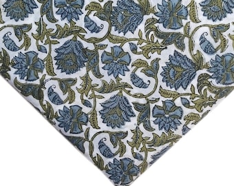 May include: White fabric with a blue and green floral pattern. The fabric has a repeating pattern of stylized flowers and leaves.
