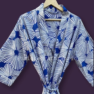 May include: A blue and white cotton robe with a floral print. The robe has a tie belt and long sleeves.