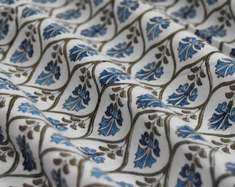 May include: White fabric with a repeating pattern of blue and brown stylized floral designs.