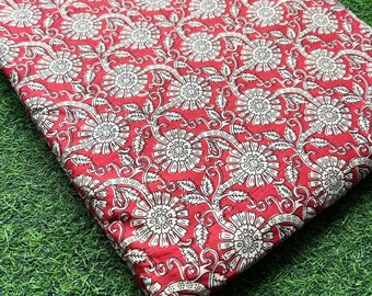Pode incluir: Tecido vermelho com um padrão floral branco. O tecido tem um padrão repetitivo de flores brancas com detalhes intrincados em um fundo vermelho.