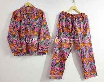 May include: Pink pajama set with a zebra and leopard print. The top has a button-up front and long sleeves. The pants have an elastic waistband.