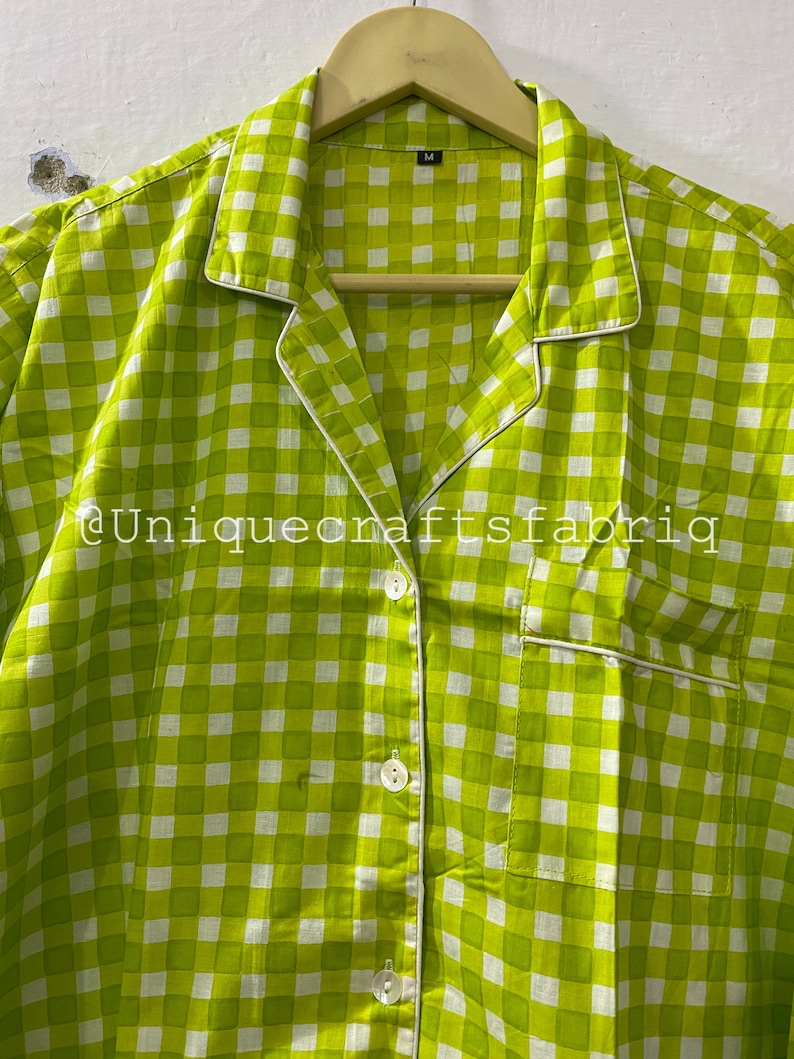 Peut inclure: Une chemise boutonn&eacute;e &agrave; carreaux verts et blancs avec une bordure blanche autour du col et des poches. La chemise a une fermeture boutonn&eacute;e et une &eacute;tiquette de taille indiquant "M".