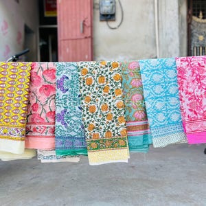Pu&ograve; includere: Sei pannelli di tessuto con motivi diversi sono appesi a una barra di metallo. I pannelli sono di vari colori, tra cui giallo, rosa, verde, blu e bianco. I pannelli sono tutti in cotone e hanno una variet&agrave; di motivi floreali e geometrici.