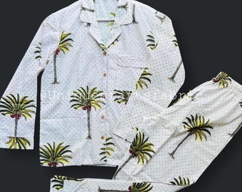 May include: White pajama set with a palm tree print and white polka dots. The top has a button-up front and long sleeves. The pants have an elastic waistband.