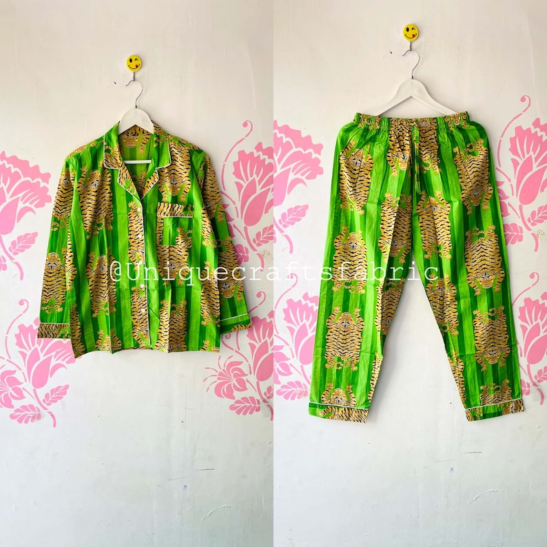 以下が含まれることがあります： 緑と金のストライプの虎柄のパジャマセット。トップはボタン留めと長袖。パンツはゴムウエストバンドです。