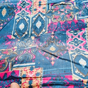 May include: Close-up of a fabric with a patchwork design. The fabric features a combination of blue, pink, and tan colors. The design includes geometric shapes and floral patterns. The text "@uniquecraftsfabric" is visible.