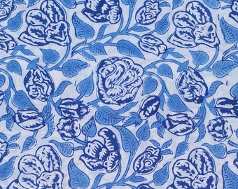 May include: A white fabric with a blue floral pattern. The pattern features stylized flowers and leaves.