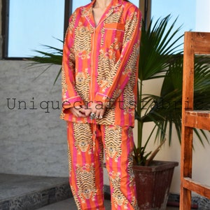 May include: Orange and pink striped pajamas with a tiger print. The pajamas have a white piping detail around the collar and cuffs.