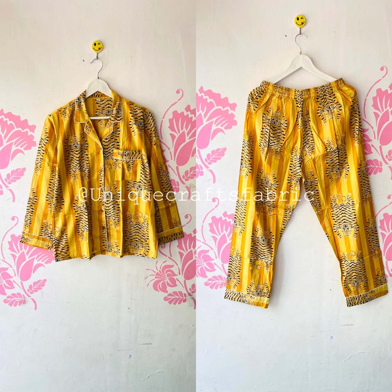 以下が含まれることがあります： 虎柄の黄色と黒のストライプの部屋着セット。トップスは襟と長袖。パンツはゴムウエストバンドです。