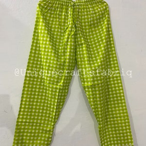 Peut inclure: Pantalon de pyjama &agrave; carreaux vert et blanc avec une taille &agrave; cordon. Le pantalon est suspendu &agrave; un cintre. Le texte "@uniquecraftsfabrig" est visible dans le coin inf&eacute;rieur gauche de l'image.