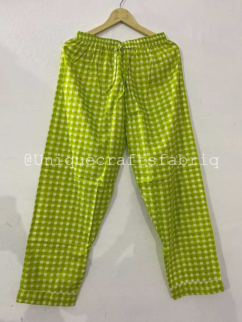 Peut inclure: Pantalon de pyjama &agrave; carreaux vert et blanc avec une taille &agrave; cordon. Le pantalon est suspendu &agrave; un cintre. Le texte "@uniquecraftsfabrig" est visible dans le coin inf&eacute;rieur gauche de l'image.