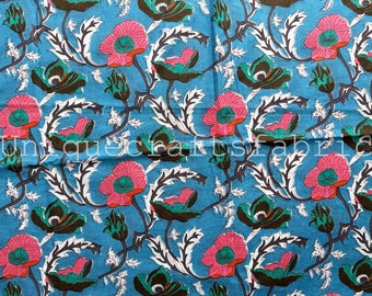 May include: Blue cotton fabric with a floral print featuring pink, green, and brown poppy flowers. The fabric has a white background with a subtle dotted pattern.