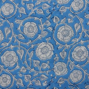 May include: A blue fabric with a white floral pattern. The flowers are stylized and have a simple design. The fabric is perfect for crafting projects or making clothing.
