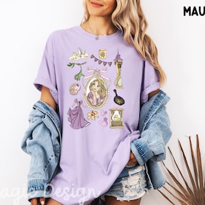 Peut inclure: T-shirt mauve avec des illustrations d'un conte de fées. Le motif comprend un portrait, une robe et d'autres éléments thématiques. Le t-shirt est de couleur violet clair.