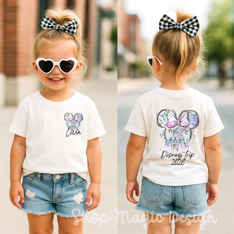 Puede incluir: Camiseta blanca con un dise&ntilde;o colorido de Mickey Mouse en la parte delantera y trasera. La parte delantera de la camiseta tiene el nombre "Livin" y la trasera dice "Disney Trip 2026". La camiseta se combina con pantalones cortos vaqueros.