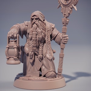 May include: A detailed miniature figurine of a dwarf wizard holding a lantern and a staff. The dwarf is wearing a long robe with intricate details and has a long beard. The miniature is painted in a light brown color.