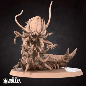 Peut inclure: Figurine beige d'une créature monstrueuse avec de multiples pattes, des dents acérées et de longues antennes incurvées. La figurine est posée sur une base circulaire, avec le texte "Bite the Bullet" visible.