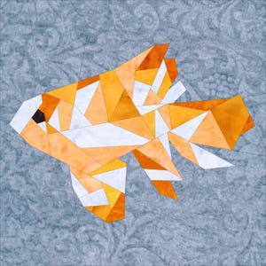 May include: A geometric orange and white fish made of fabric pieces. The fish is on a blue background with a floral pattern.