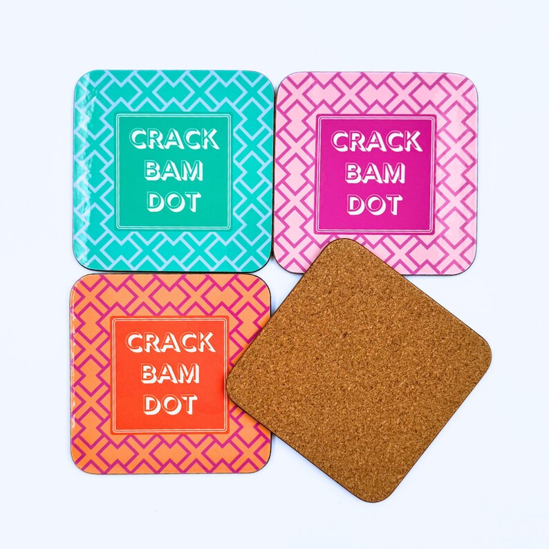 May include: Four square coasters with a geometric pattern in turquoise, pink, and orange. Each coaster features the text "Crack Bam Dot" in white.