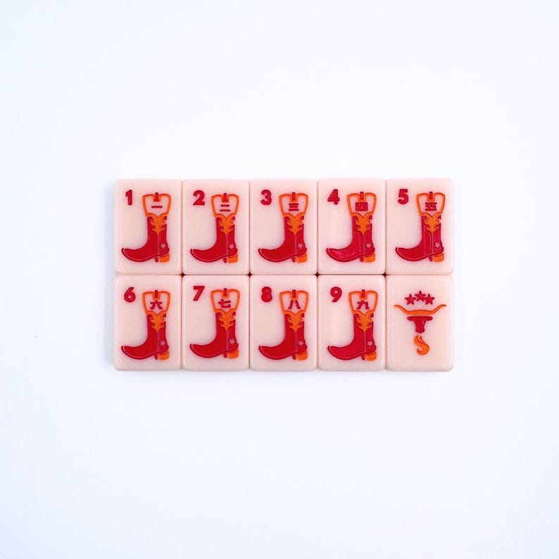 May include: A set of ten pink tiles with red cowboy boot designs and Chinese characters. The tiles are numbered 1 through 9, with the tenth tile featuring a cowboy hat and stars.