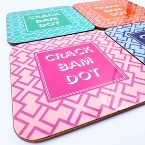 May include: Four pink, blue, green, and orange coasters with a geometric pattern and the text "Crack Bam Dot" in white.