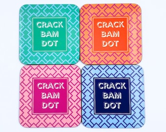 Könnte beinhalten: Satz mit vier quadratischen Untersetzern mit geometrischem Muster. Jeder Untersetzer zeigt den Text "CRACK BAM DOT" in weißen Buchstaben auf einem andersfarbigen Hintergrund: Türkis, Orange, Rosa und Blau.