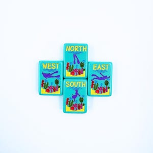 May include: Four turquoise blue tiles with a scuba diver and coral reef design. Each tile has a different direction: North, South, East, and West.