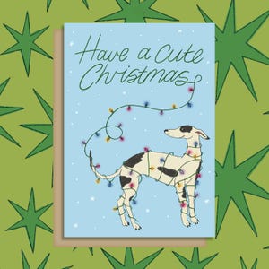 Tenha um cartão de felicitações de Natal fofo, um galgo whippet fofo enroscado em luzes de Natal. Perfeito para donos de cachorro!