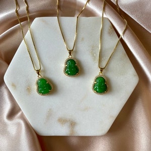 May include: Three gold chains with green jade Buddha pendants. The pendants are detailed with small clear stones.