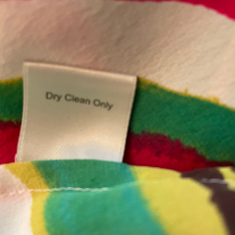 Peut inclure: &Eacute;tiquette blanche avec le texte "Dry Clean Only" sur un fond de tissu color&eacute;.
