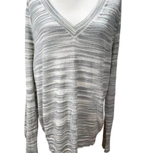 Puede incluir: Un su&eacute;ter de manga larga con cuello en V en un patr&oacute;n de rayas grises y blancas. El su&eacute;ter se muestra en un maniqu&iacute;. La tela parece ser un tejido de punto ligero, adecuado para usar en capas. El cuello y los pu&ntilde;os tienen una textura acanalada.