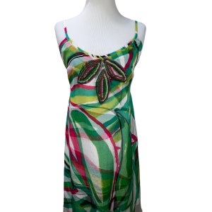 Peut inclure: Une robe sans manches blanche, verte et rose avec un motif floral perl&eacute; sur l'encolure.