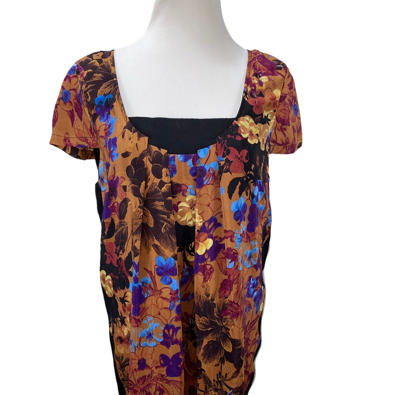 May include: A brown and black floral print top with a black square neckline. The top has a loose fit and is made of a soft, comfortable fabric.