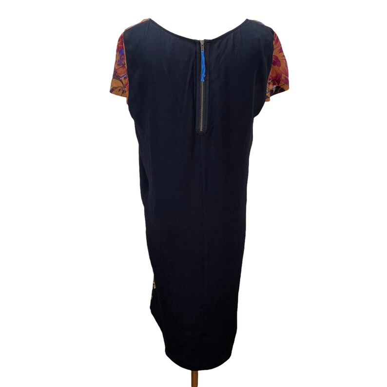 May include: A black midi dress with a floral print on the sleeves. The dress has a zipper down the back.