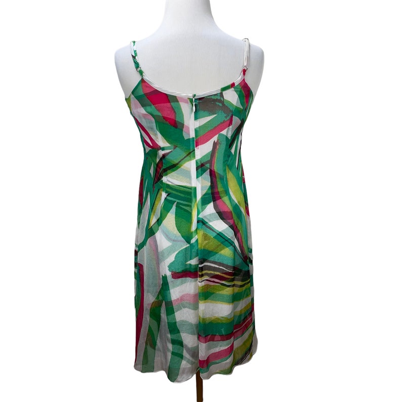 Peut inclure: Une robe sans manches blanche, verte et rose avec un imprim&eacute; g&eacute;om&eacute;trique. La robe a un corsage ajust&eacute; et une jupe ample.