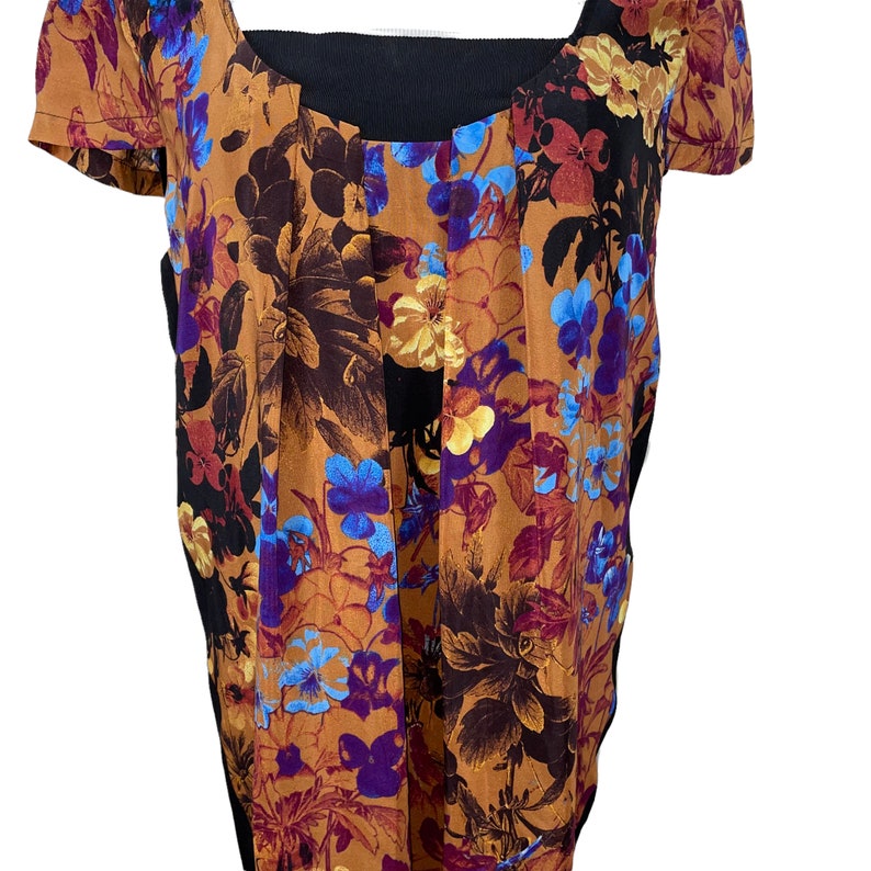 May include: A brown and black floral print blouse with a black scoop neck and short sleeves.
