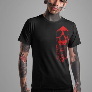 K&ouml;nnte beinhalten: Ein schwarzes T-Shirt mit einem roten Totenkopf-Motiv auf der Vorderseite. Der Totenkopf ist in einer Diamantenform und hat ein detailliertes Design.