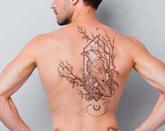 May include: A man with a black line drawing tattoo on his back. The tattoo features a crow perched on a branch with geometric shapes and leaves.