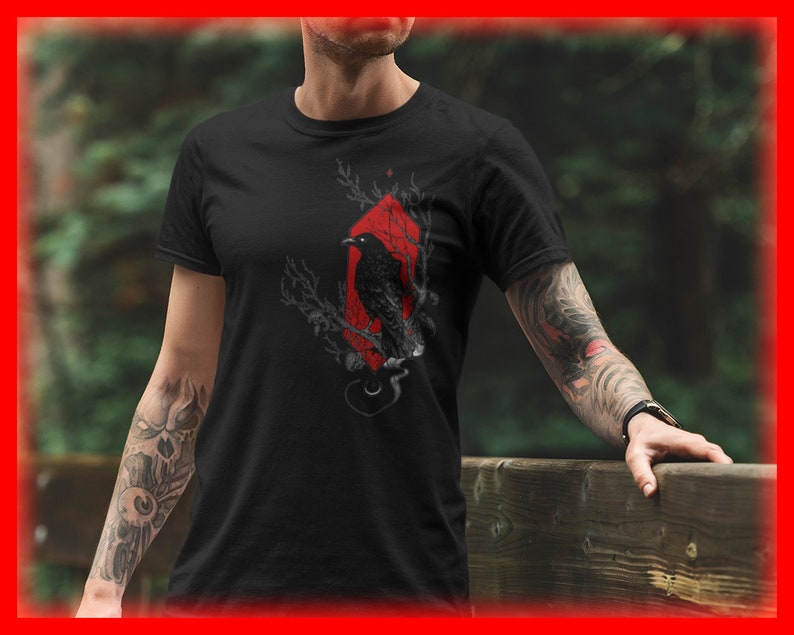 May include: Black t-shirt with a graphic of a crow perched on a branch in a red diamond shape.