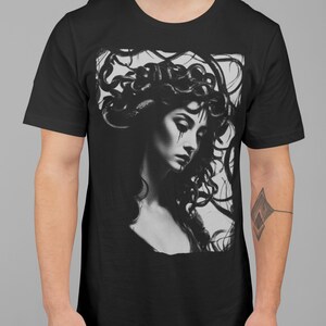 May include: Black t-shirt with a graphic print of a woman with snakes for hair. The woman is looking down and has a sad expression on her face.