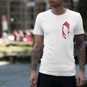 May include: White t-shirt with a red graphic of a bird inside a geometric shape. The graphic has a distressed look.