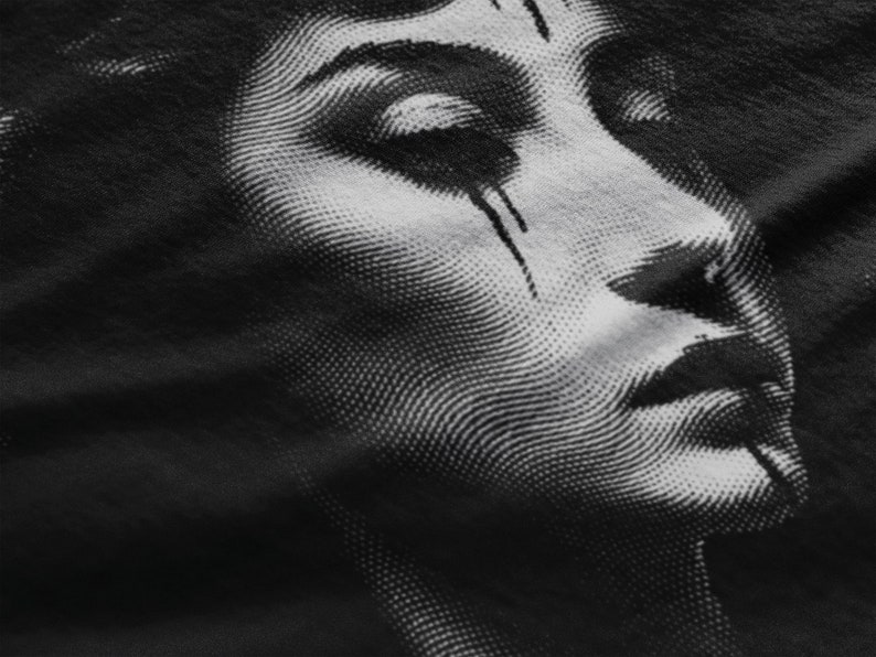 May include: Close-up of a black and white halftone image of a woman's face. The image is printed on a black fabric.