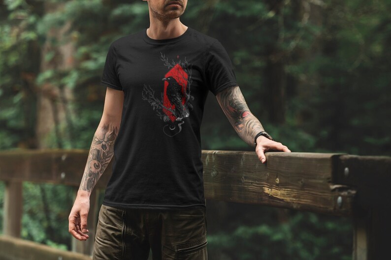 May include: Black t-shirt with a graphic of a raven in a red diamond shape.