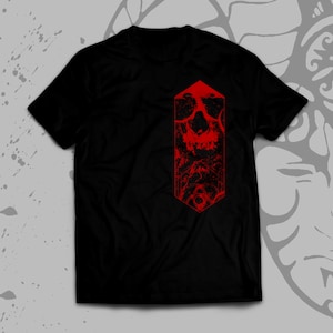 K&ouml;nnte beinhalten: Schwarzes T-Shirt mit einem roten Totenkopf-Motiv auf der Vorderseite. Der Totenkopf befindet sich in einer sechseckigen Form und hat einen verwitterten Look.
